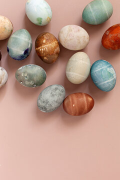 Colorful painted eggs on beige surface