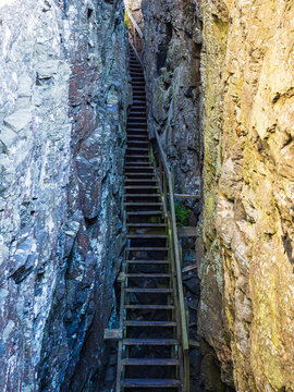 Long wooden stairs climbing up through narrow rock canyon