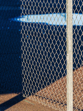 Metal chain link fence in sunlight