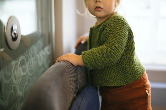 Midsection of girl walking over seat in train