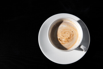 Fototapeta premium Premium dark roast arabica coffee beans with cozy cup of warm steaming coffee and sugar on dark background with copy space