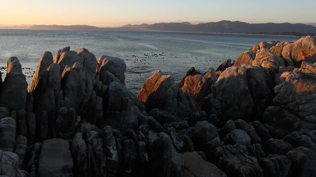 rocky coastline of DeKelders, Gansbaai, South Africa at sunset
