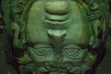 Ancient Roman upside down Medusa head statue in the Basilica Cistern, Istanbul, Turkey. Close-up macro shot of the mysterious mythological marble sculpture used as a pillar base, Byzantine landmark © AAUB