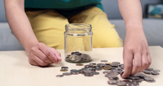 A child carefully counts coins promoting financial literacy and saving habits in a cozy home environment.