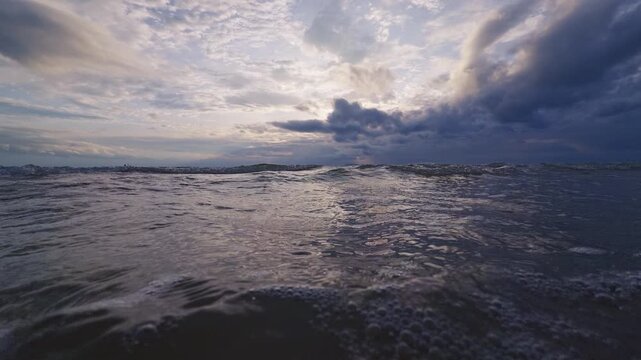 Extreme Close View of Sea Foam and Ocean Surface Under Dramatic Cloudy Sunset Sky, Slow Motion Tropical Wave Texture and Nature