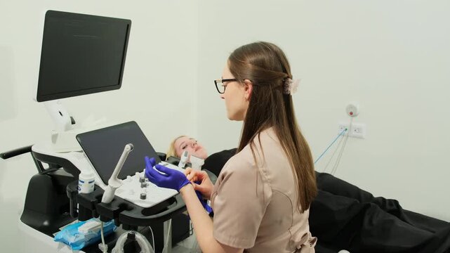Gynecologist puts on gloves and turns on ultrasound machine in medical office slow motion. Doctor examines patient small pelvis organs in hospital