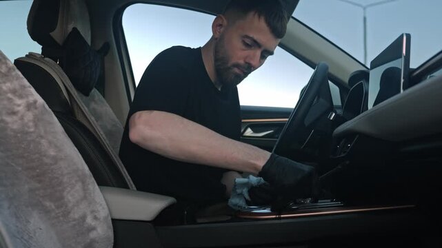 White Man Car Owner Wiping Center Console, Removing Crumbs And Sticky Residue With Microfiber, Black Gloves,