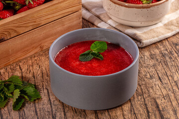 Homemade strawberry puree garnished with mint in grey bowl
