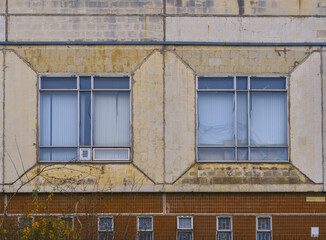 Obraz premium Suburban window with curtains. Close shot of residential window with aged details and soft lighting