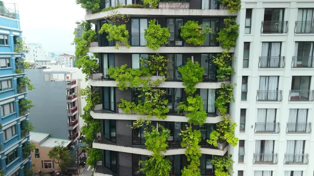 Modern architectural building integrating lush green plants on balconies, creating a vertical garden and promoting urban greening with sustainable eco friendly design in a city