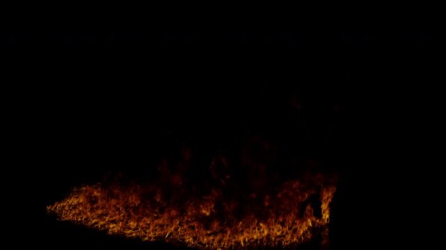 Realistic ground fire burning with intense flames and sparks on a black background for visual effects compositing.