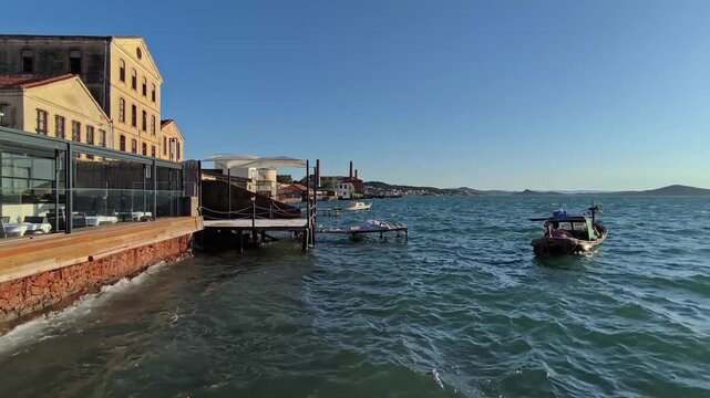 Wavy Sea, Rowboat and Historical Stone Buildings on Ayvalik Coast