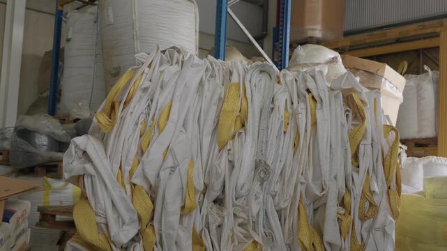 Large bundle of white and yellow plastic straps piled on floor inside industrial warehouse facility