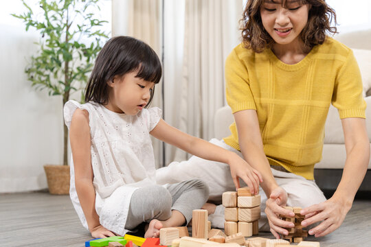 Mother, daughter, family support, education, homeschool parent and happy child playing wooden toy block together, building intelligence through fun activity, emotional quotient and early development