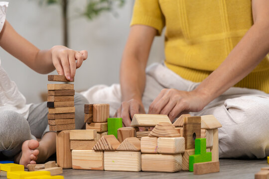 Mother, daughter, family support, education, homeschool parent and happy child playing wooden toy block together, building intelligence through fun activity, emotional quotient and early development
