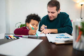 Naklejka premium Father and son drawing together while working from home