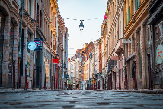 Rue pav&eacute;e de Lille photographi&eacute;e au ras du sol, avec des boutiques et des b&acirc;timents historiques dans le charmant centre historique de la ville - France