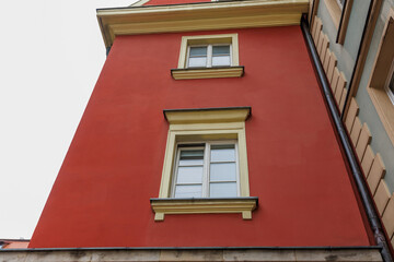 Obraz premium Low angle view of historic red building facade with windows