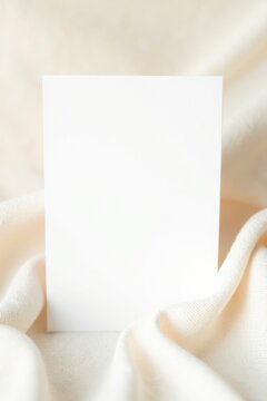 Tarjeta en blanco colocada en el centro sobre un fondo de tela de lino suave con una textura sutil