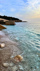 Fototapeta premium Dobra Voda shoreline with turquoise Adriatic water and stone quay at sunrise