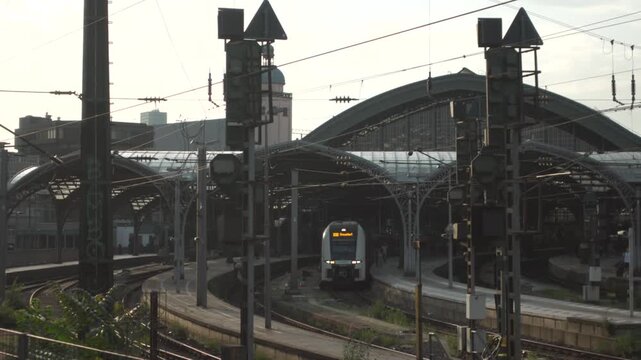Koln Hauptbahnhof Nordrhein-Westfalen Deutschland. Main station of Cologne in Germany outside view of rails, tracks and roof at sunset in summer located in city center next to Cologne Cathedral. 