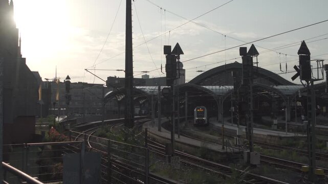 Koln Hauptbahnhof Nordrhein-Westfalen Deutschland. Main station of Cologne in Germany outside view of rails, tracks and roof at sunset in summer located in city center next to Cologne Cathedral. 