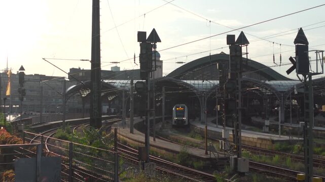 Koln Hauptbahnhof Nordrhein-Westfalen Deutschland. Main station of Cologne in Germany outside view of rails, tracks and roof at sunset in summer located in city center next to Cologne Cathedral. 