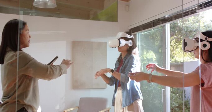 Female guide leading meeting room with tablet center woman reaching white VR headset following cues
