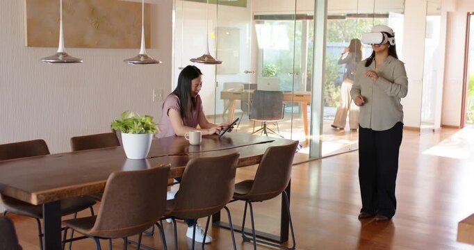 Female team at home seeing VR causing woman gesturing and testing, peer tapping tablet, copy space