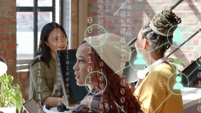Three women joining loft desk discussing tech as binary nodes overlaying faces and screens