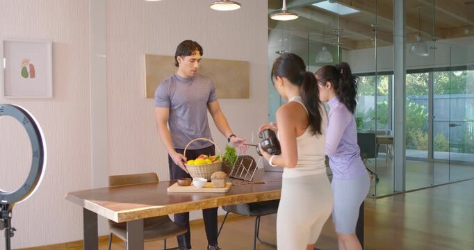 Colleagues styling product on wood table women approaching with camera displaying salad bag