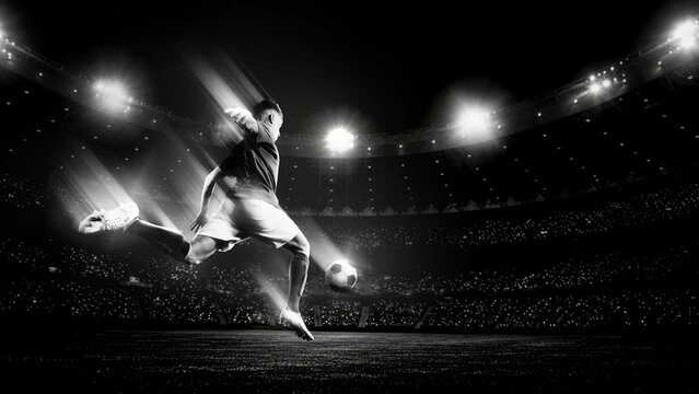 Soccer player jumping for powerful kick in black and white stadium light. Concept of decisive attack, dramatic match moment, sport campaign and cinematic football energy.