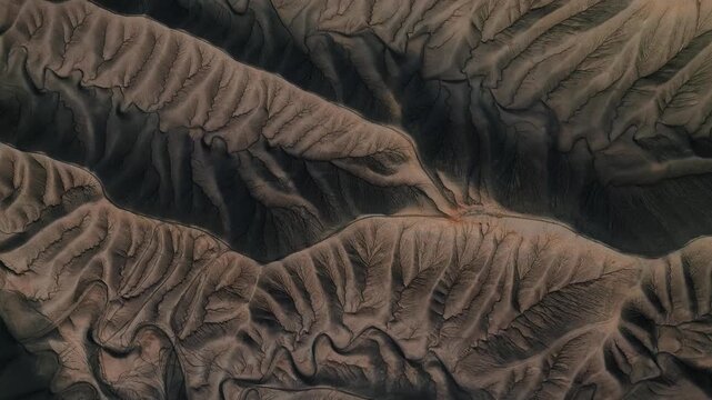 16 March 2026: Aerial view of intricate eroded ridges and deep valleys in a dark desert landscape with sharp crests and shadows.