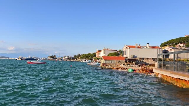 Wavy Sea, Rowboat and Historical Stone Buildings on Ayvalik Coast