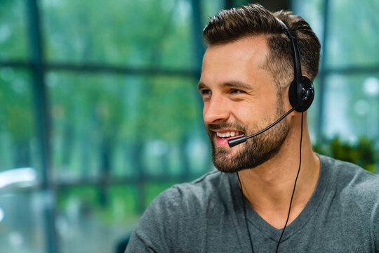 Close up man wear headset with microphone smile look aside. Internet selling worker, tutor provide lecture for trainee distantly, company representative contact with client online concept