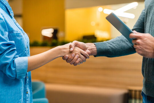 Close-up photo of two hands shaking in an office, symbolizing a professional agreement, partnership, or successful collaboration in a business setting.