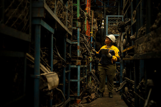 African female engineer checking auto parts inventory with a tablet in warehouse
