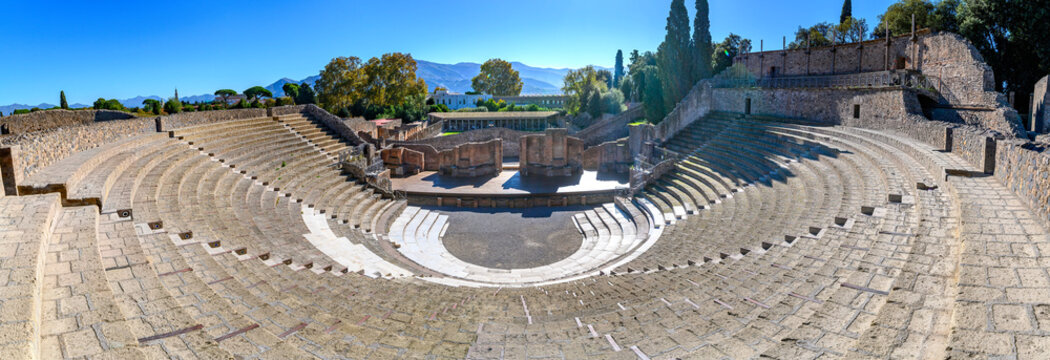 Panoramic view of the ancient Great Theater (Teatro Grande) and the scenic mountain backdrop in the archaeological site of Pompeii, Italy