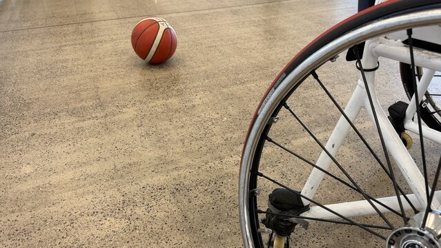 Wheelchair basketball training concept with ball on indoor court