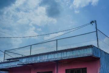 Fototapeta premium Pink building with metal railing and blue sky background