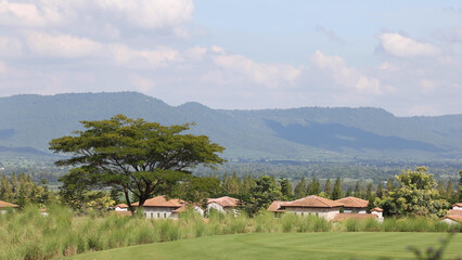 Fototapeta premium Panoramic View of a Rural Village Nestled Against Lush Green Mountains