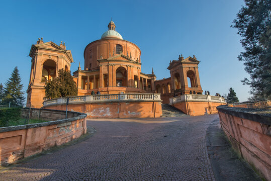 View of the Santuario Madonna di San Luca with its iconic dome and circular portico under a clear blue sky in Bologna, Emilia-Romagna, Italy.