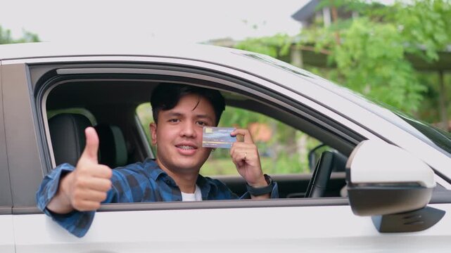 New Driver License: A young man beams with pride, showcasing his brand new driver's license from the car window, an emblem of freedom, and the open road.