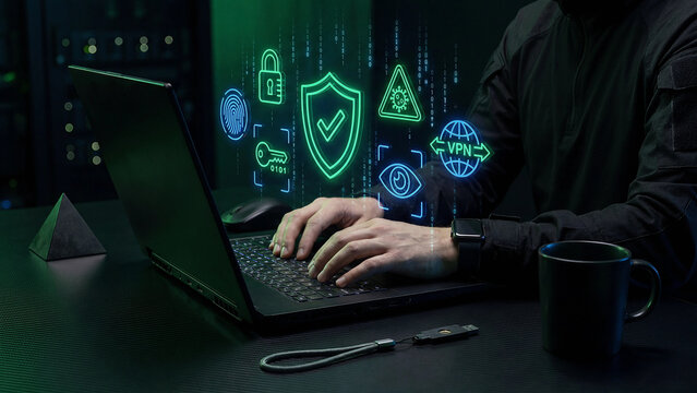 Cybersecurity and VPN Protection Concept Man Typing on Black Laptop with Glowing Green Neon Shield Fingerprint Lock Virus Warning Eye Key Binary Code Dark Server Room Background