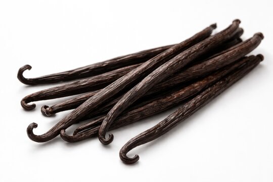 Sharp close up of fresh vanilla bean pods colored dark brown displayed on a plain white background