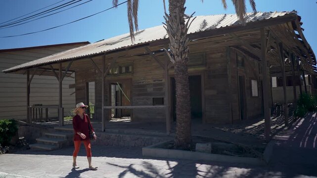 Mature woman explores Santa Rosalia, enjoying the details of local French architecture and the vibrant surroundings in Baja California Sur, Mexico..