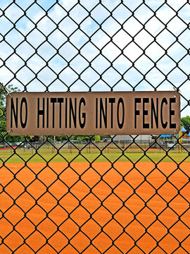 Sign on the baseball field fence: Do not hit the fence.
