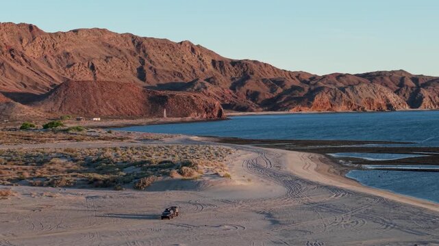 Aerial view of teardrop camper trailer camping on the beach at sunrise near Papa Fernandez in Baja California Mexico by the Sea of Cortez.