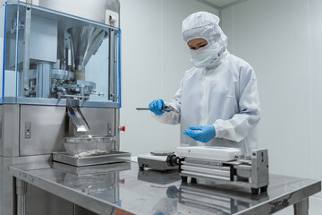 Naklejka premium The scene emphasizes sterile conditions. Professional scientists in cleanroom suits inspecting pharmaceutical manufacturing processes and operating industrial mixing equipment.