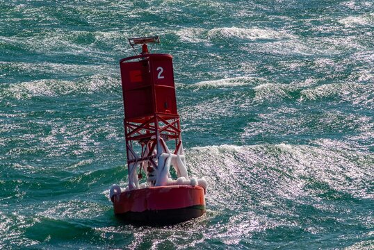 View of a red navigation buoy floating in the choppy green waters off Martha's Vineyard Edgartown, Massachusetts, United States.